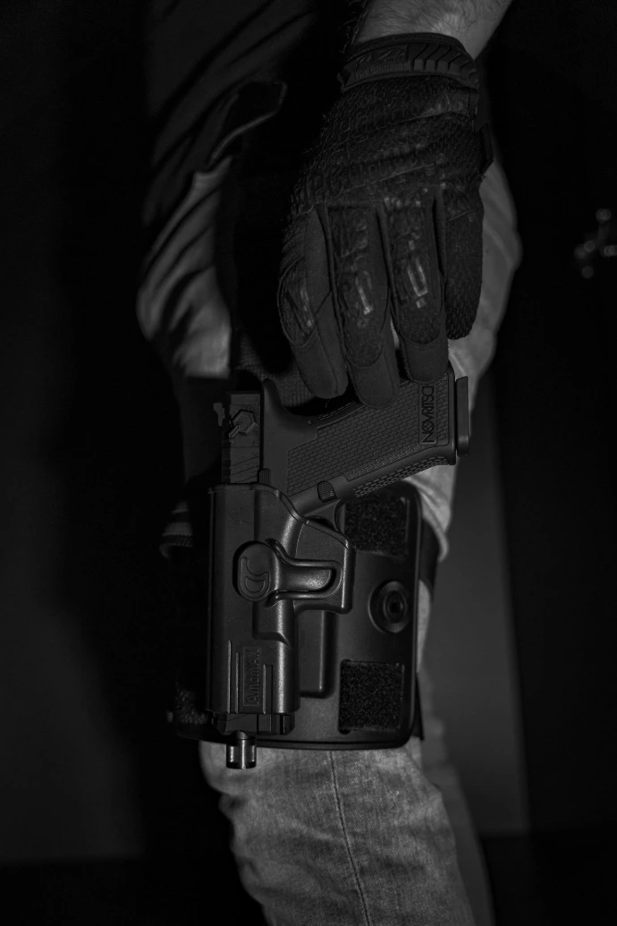 a black and white photo of a person holding a gun